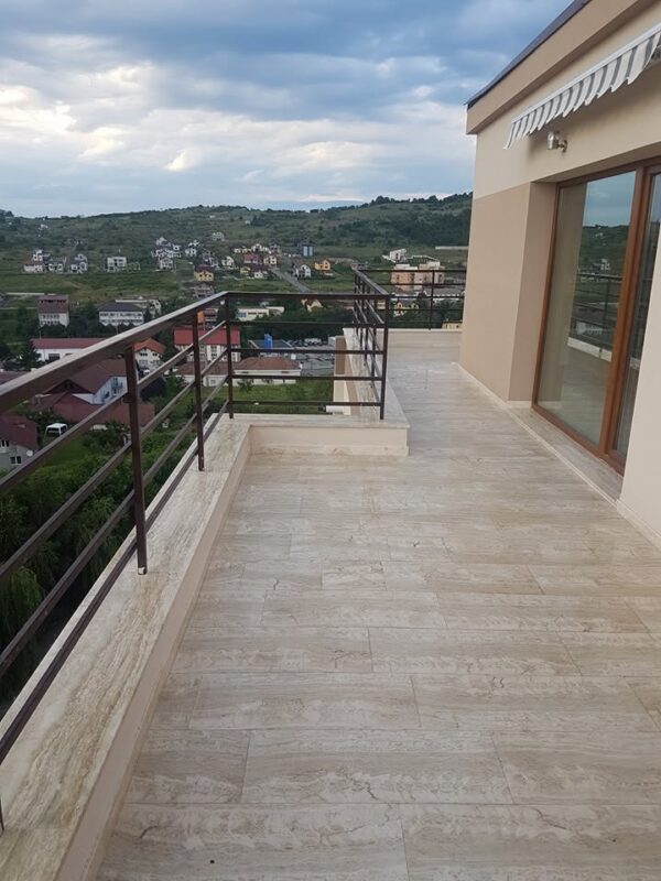 Terasă exterioară placată cu travertin Silver bej-gri și balustradă metalică cu vedere panoramică