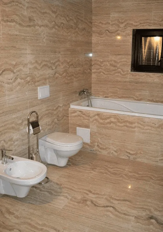 Baie modernă placată cu travertin natural bej pe pereți și pardoseală