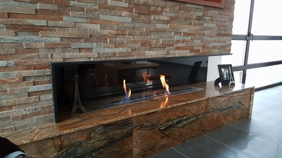 Bioșemineu modern cu placare din piatră naturală și blat decorativ din granit cu venaturi spectaculoase