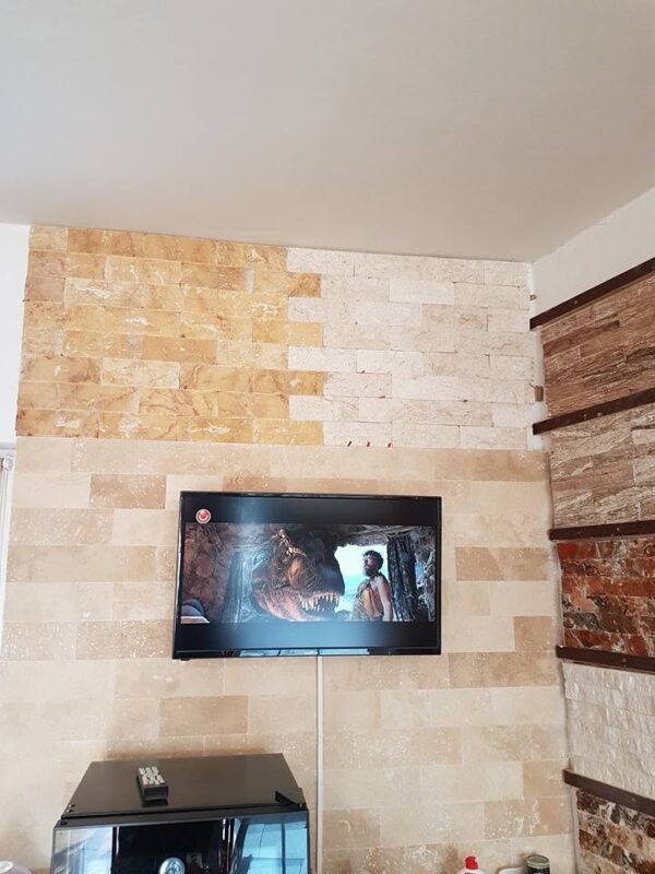 Perete interior placat cu travertin natural și piatră decorativă bej în zona TV