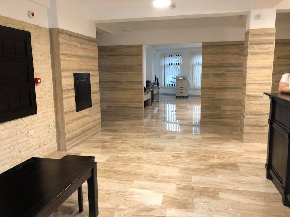 Pardoseală lucioasă și placări din travertin natural într-un spațiu de birouri modern