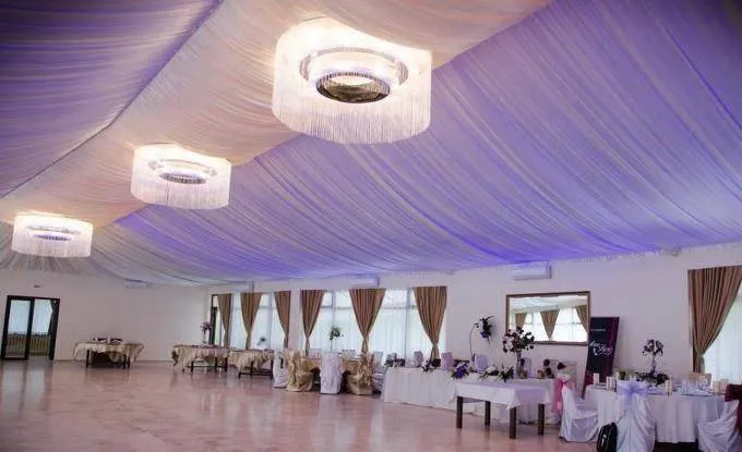 Sală de nunți cu pardoseală din piatră naturală crem și decor elegant pentru evenimente