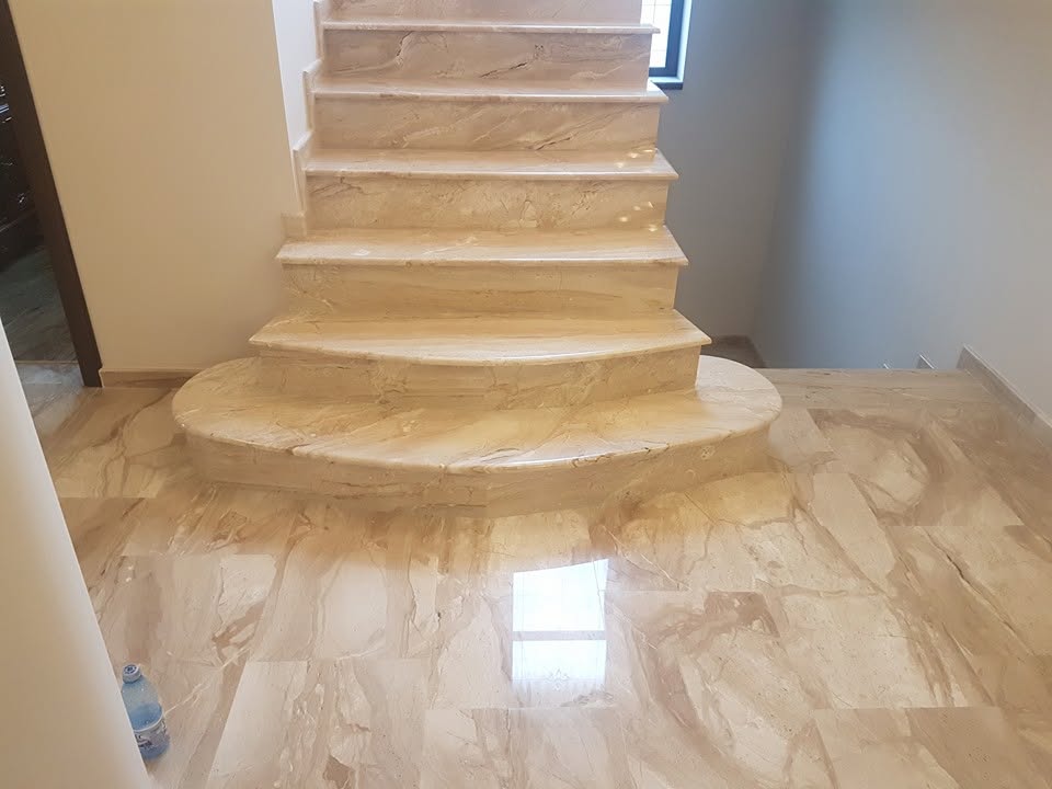 Scări interioare din marmură crem lucioasă și pardoseală din piatră naturală în hol rezidențial
